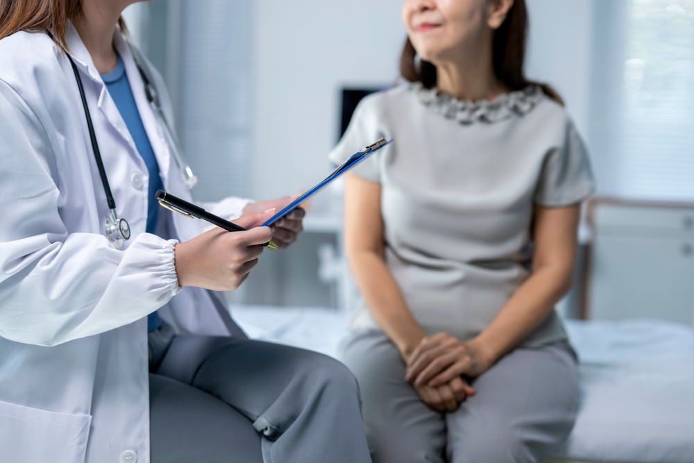 A,Woman,Is,Sitting,On,A,Hospital,Bed,While,A