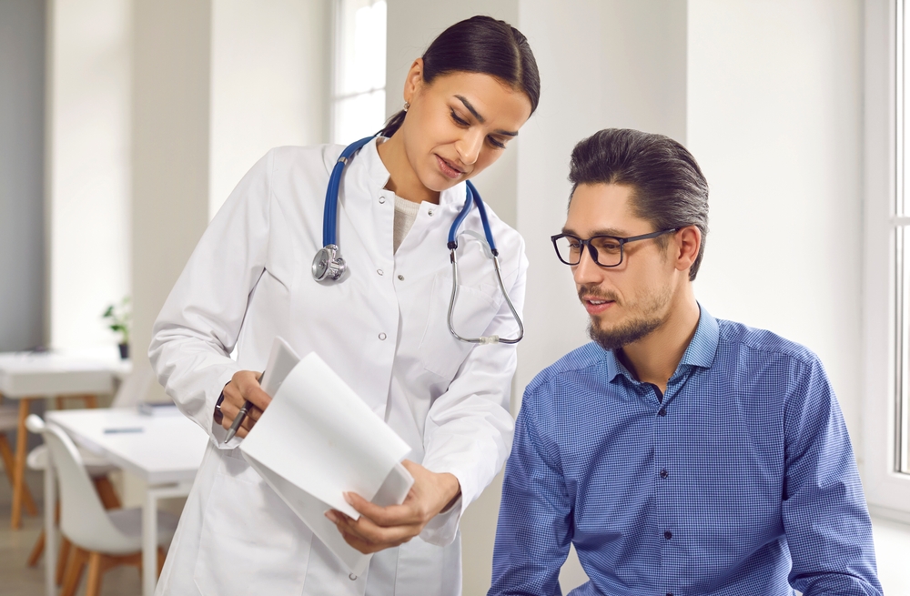 Female,Doctor,Showing,Test,Results,To,Male,Patient,In,Medical